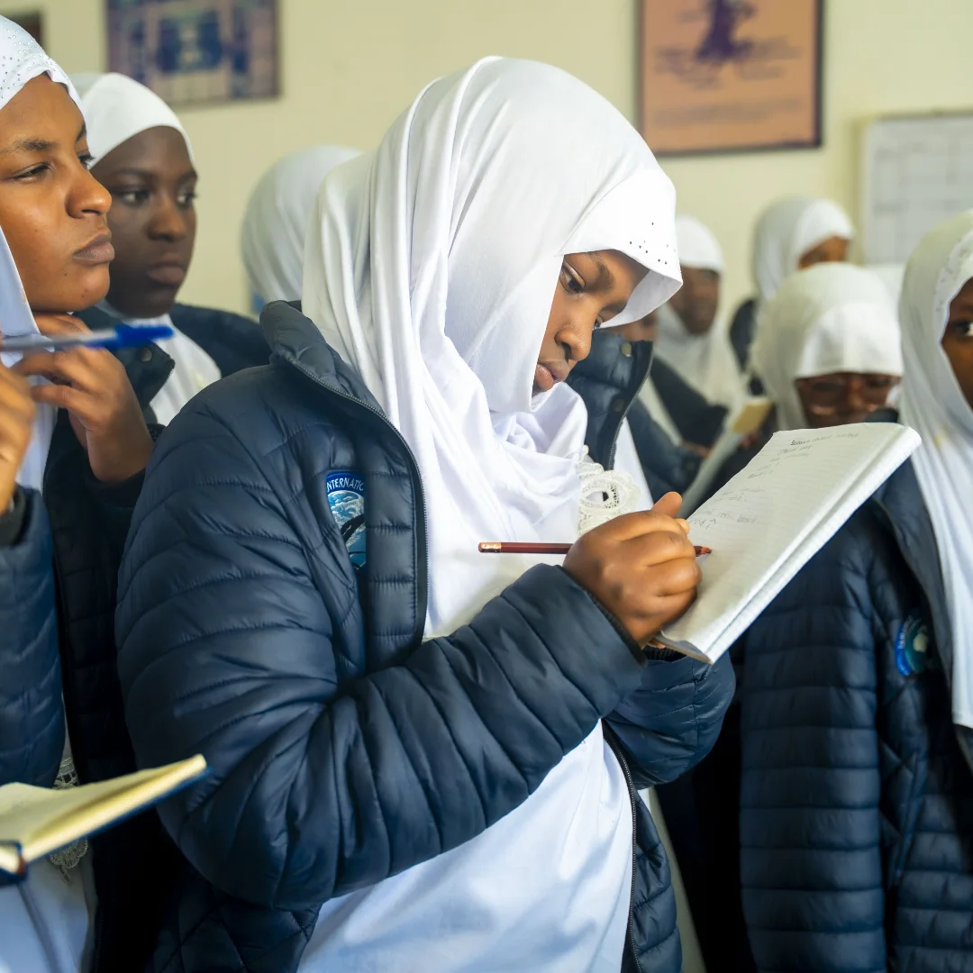 A Tamayuz International Academy student taking notes during a science lesson